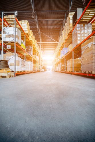 Warehouse industrial and logistics companies. Long shelves with a variety of boxes and containers. Toning the image. Bright sunlight.